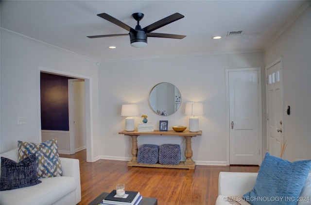 living room with hardwood / wood-style flooring, ceiling fan, and crown molding