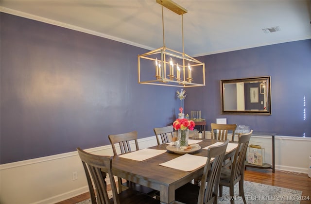 dining room featuring a chandelier, wood-type flooring, and ornamental molding