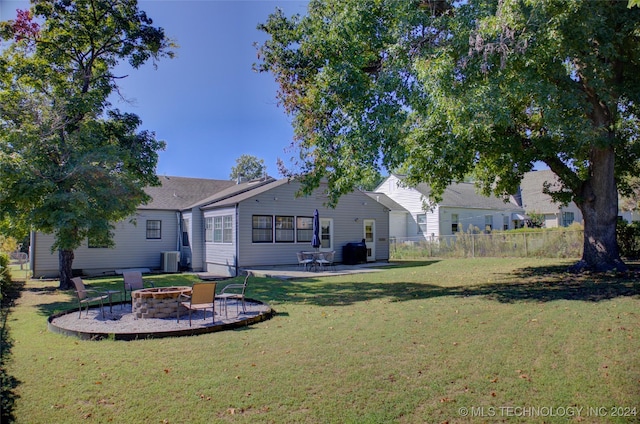 rear view of house with a yard, a fire pit, a patio area, and central air condition unit