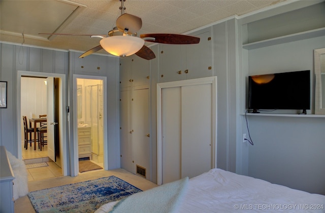 bedroom with connected bathroom, ceiling fan, and light tile patterned floors