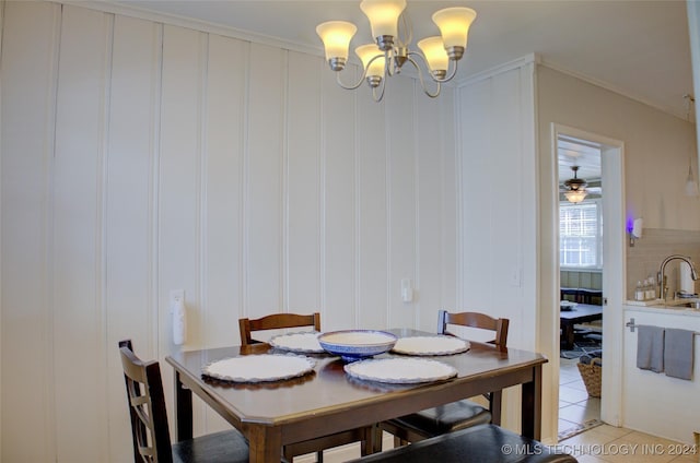 tiled dining area with ceiling fan with notable chandelier, ornamental molding, and sink