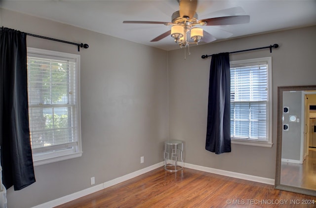 spare room with hardwood / wood-style floors, ceiling fan, and a healthy amount of sunlight