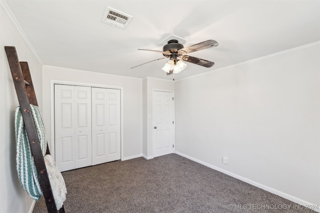 unfurnished bedroom with dark colored carpet, ceiling fan, crown molding, and a closet