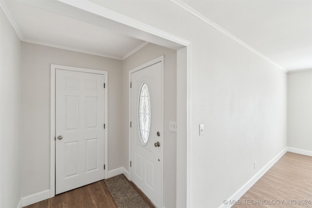 foyer entrance with wood-type flooring and crown molding