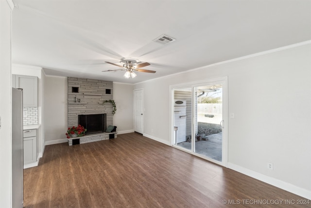 unfurnished living room featuring a stone fireplace, ceiling fan, dark wood-type flooring, and crown molding