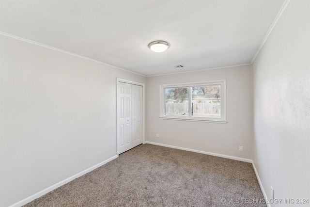 carpeted spare room featuring crown molding