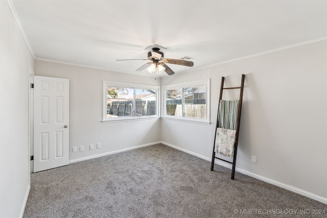 carpeted spare room with ceiling fan and ornamental molding