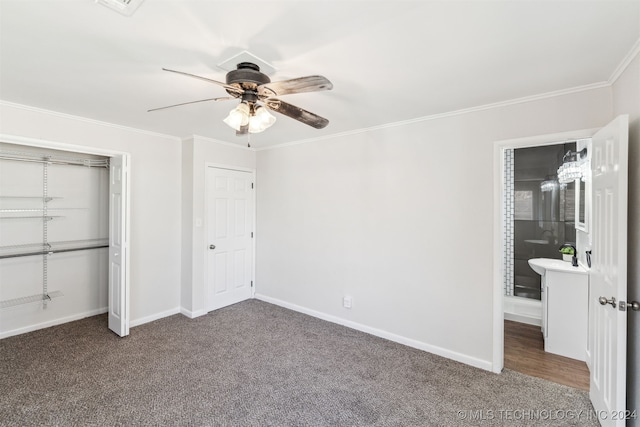 unfurnished bedroom with ceiling fan, a closet, crown molding, and dark colored carpet