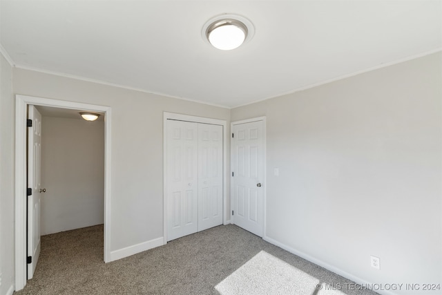 unfurnished bedroom with light carpet and a closet