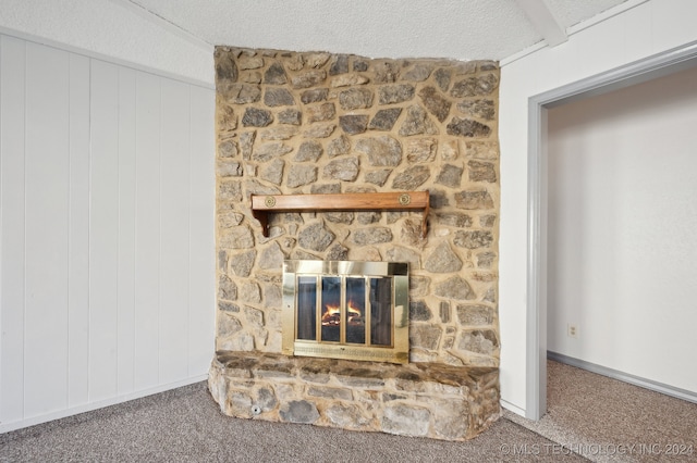 details with a stone fireplace, wooden walls, carpet, and a textured ceiling