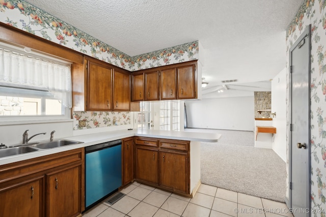 kitchen featuring sink, stainless steel dishwasher, kitchen peninsula, light colored carpet, and a textured ceiling