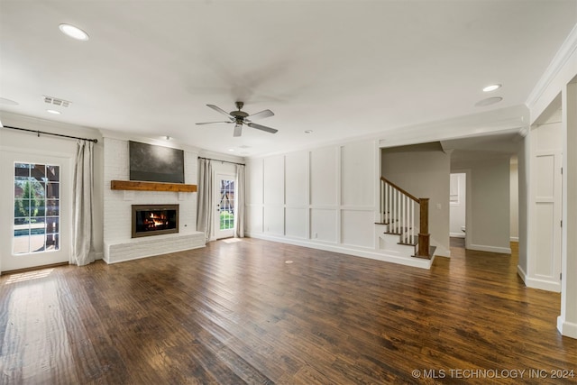 unfurnished living room featuring ceiling fan, dark hardwood / wood-style flooring, a fireplace, and crown molding