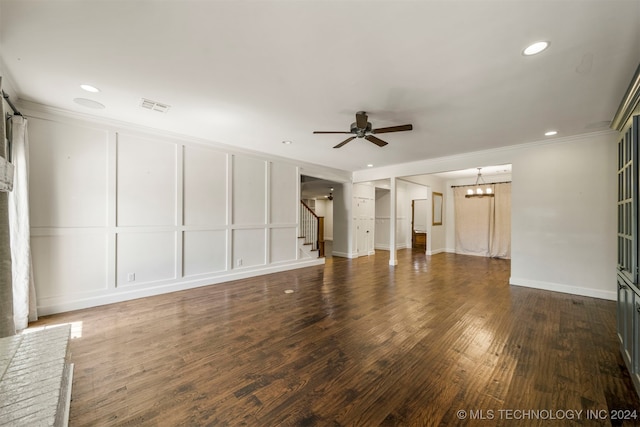 unfurnished living room with ceiling fan with notable chandelier, crown molding, and dark wood-type flooring