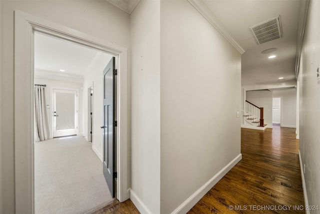 hallway with dark hardwood / wood-style flooring and ornamental molding