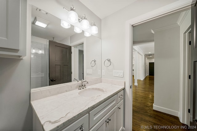 bathroom with hardwood / wood-style floors, vanity, and a shower