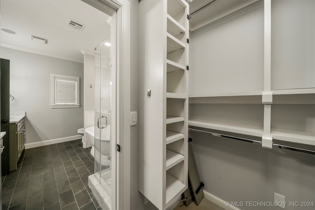 walk in closet with dark tile patterned flooring