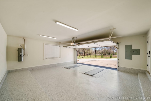 garage featuring electric panel, water heater, and a garage door opener