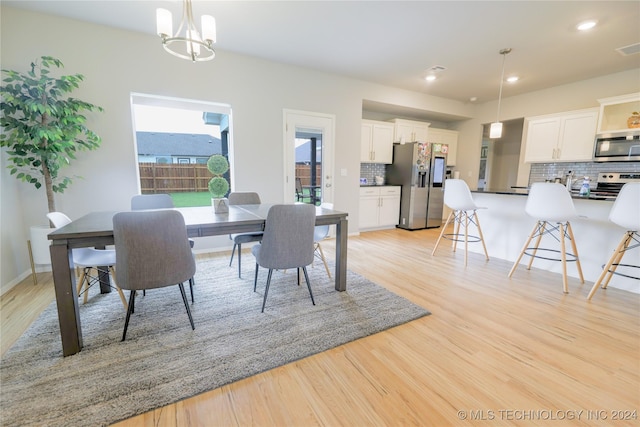 dining room with a notable chandelier and light hardwood / wood-style floors