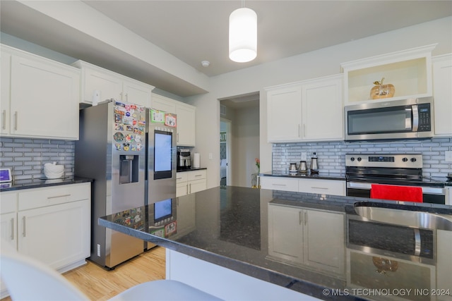 kitchen featuring decorative backsplash, white cabinetry, and stainless steel appliances