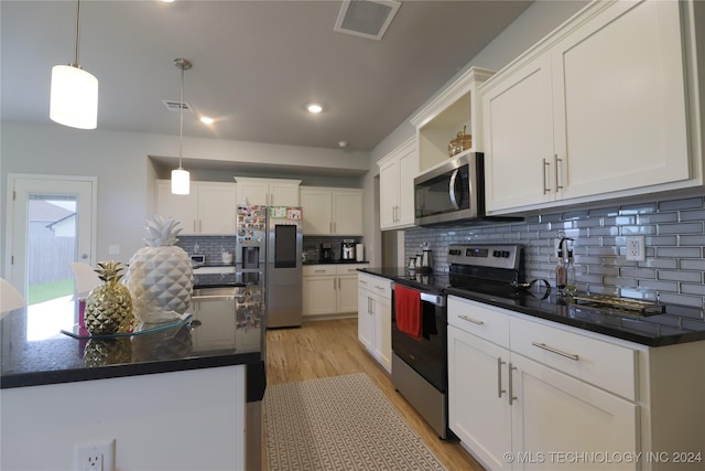 kitchen with decorative backsplash, stainless steel appliances, white cabinets, a kitchen island, and hanging light fixtures