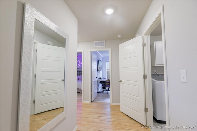 hall with washer / clothes dryer and light hardwood / wood-style floors