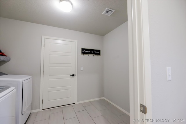 clothes washing area featuring washer and clothes dryer and a textured ceiling