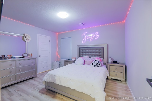 bedroom featuring a textured ceiling and light wood-type flooring