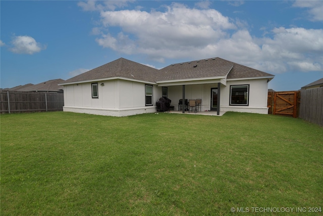 back of house with a yard and a patio area