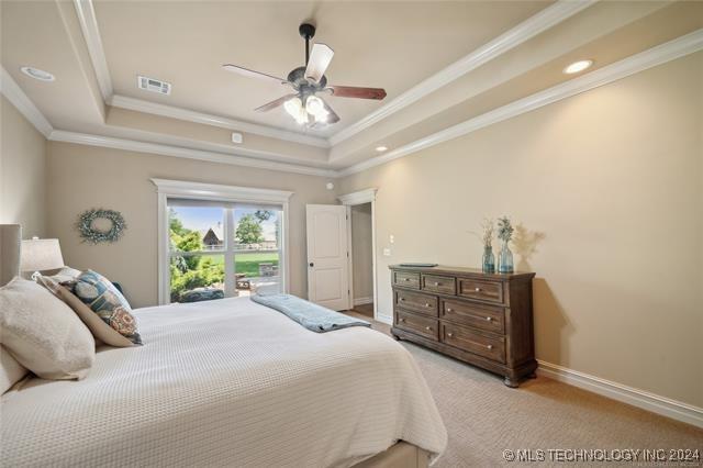 bedroom with ceiling fan, ornamental molding, and a tray ceiling