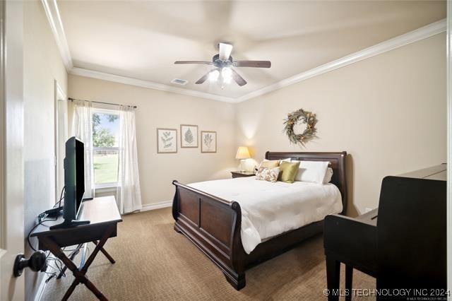 bedroom featuring light colored carpet, ceiling fan, and ornamental molding