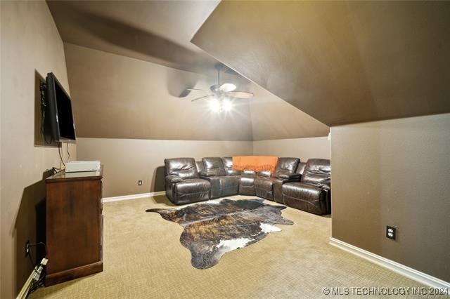 living room featuring ceiling fan, light colored carpet, and lofted ceiling