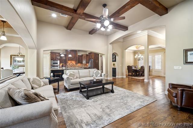 living room featuring dark hardwood / wood-style flooring, ceiling fan with notable chandelier, coffered ceiling, and beam ceiling