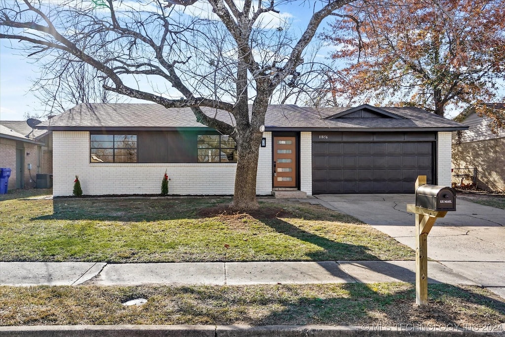 single story home featuring a garage and a front yard