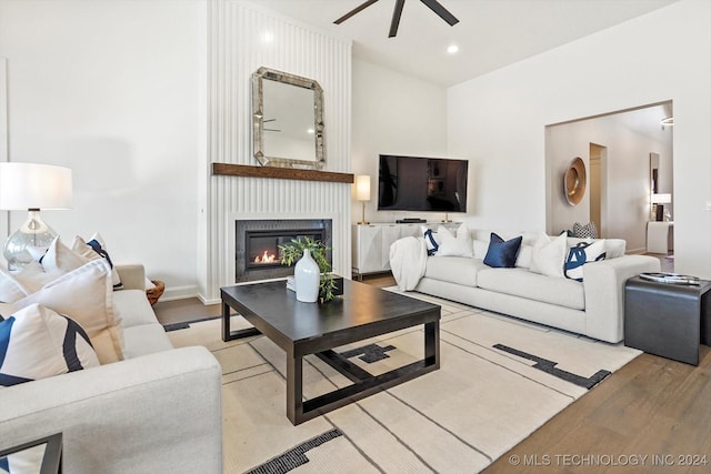 living area with ceiling fan, light wood-style flooring, recessed lighting, a fireplace, and baseboards