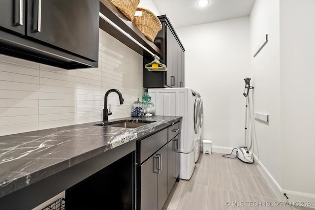 laundry room with cabinet space, light tile patterned floors, baseboards, independent washer and dryer, and a sink