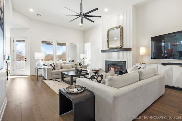 living area featuring ceiling fan, recessed lighting, dark wood finished floors, visible vents, and a glass covered fireplace