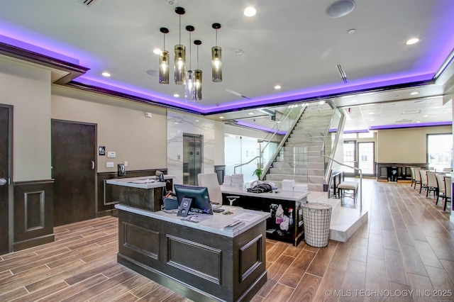 office space featuring a decorative wall, a wainscoted wall, recessed lighting, wood tiled floor, and a raised ceiling