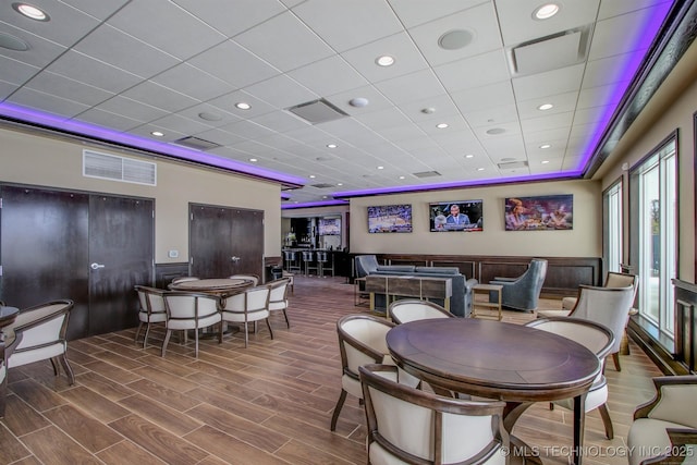 dining area featuring a wainscoted wall, wood finished floors, and visible vents