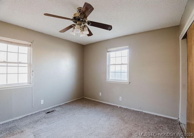 empty room with light carpet, a textured ceiling, and ceiling fan