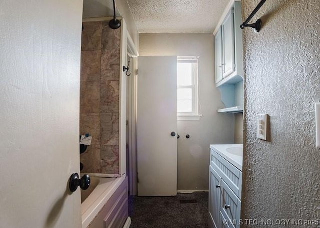 bathroom with vanity, a textured ceiling, and washtub / shower combination