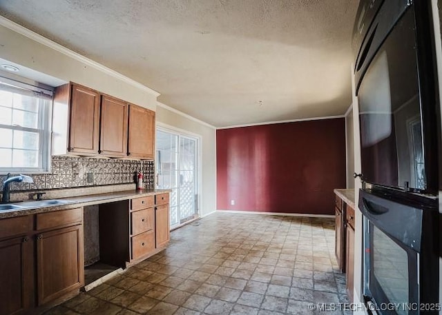 kitchen featuring a textured ceiling, tasteful backsplash, a wealth of natural light, and sink