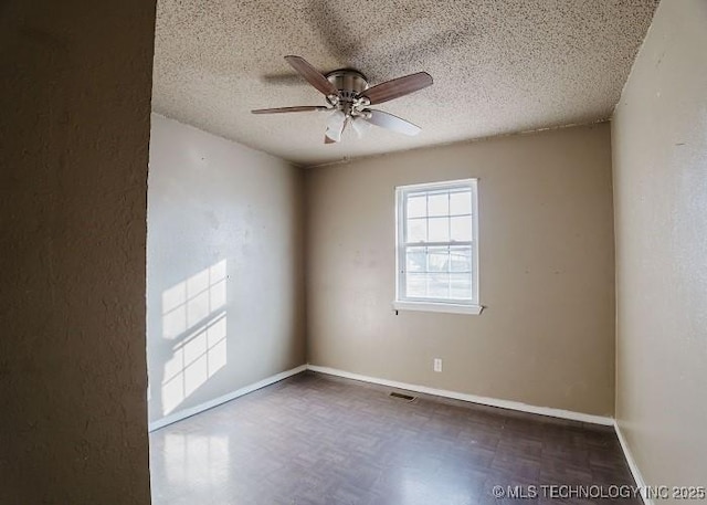 empty room featuring ceiling fan and a textured ceiling