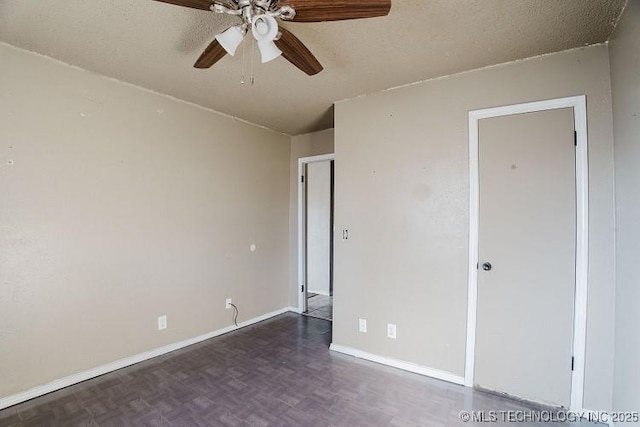 unfurnished bedroom with dark parquet floors, ceiling fan, and a textured ceiling