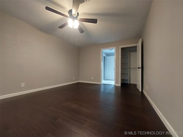 unfurnished bedroom featuring ceiling fan and dark hardwood / wood-style flooring