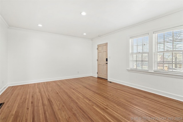 unfurnished room featuring hardwood / wood-style floors and ornamental molding