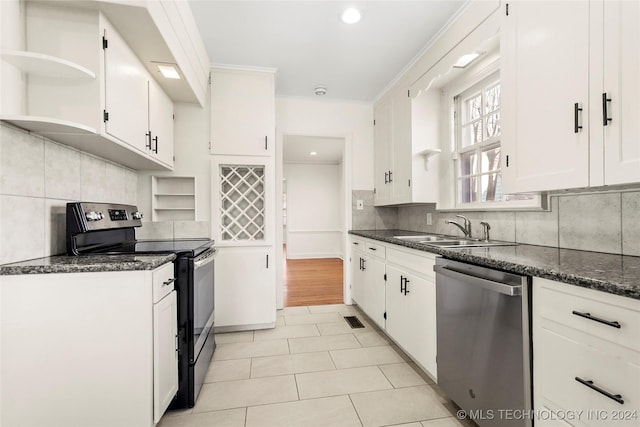 kitchen featuring dark stone countertops, white cabinetry, sink, and stainless steel appliances