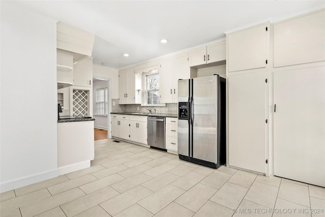 kitchen featuring sink, light tile patterned floors, appliances with stainless steel finishes, tasteful backsplash, and white cabinetry