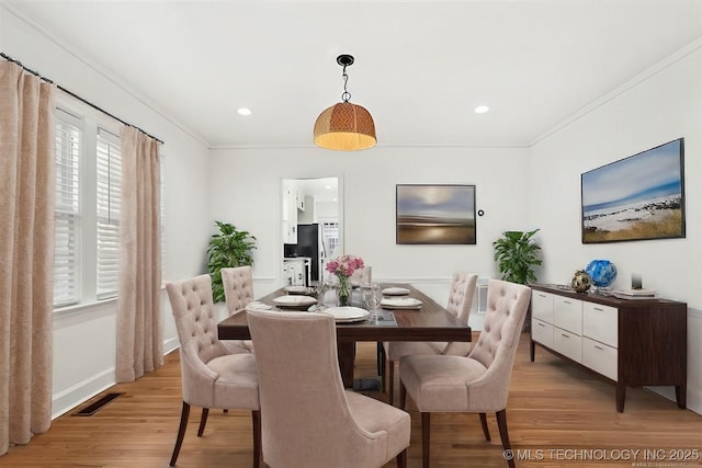 dining area featuring a wealth of natural light, crown molding, and light hardwood / wood-style floors