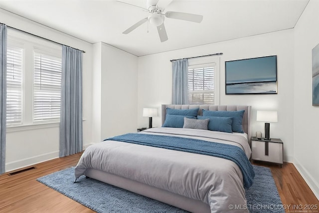 bedroom with dark hardwood / wood-style floors and ceiling fan