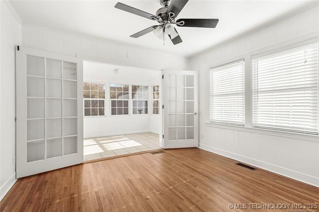 unfurnished room featuring ceiling fan, french doors, and hardwood / wood-style flooring